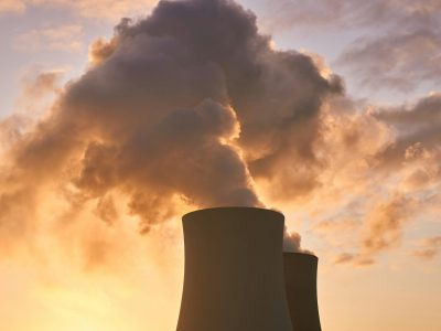 pexels-photo-3044479-3044479 Cooling towers release smoke into a dramatic sunset sky, highlighting environmental impact.